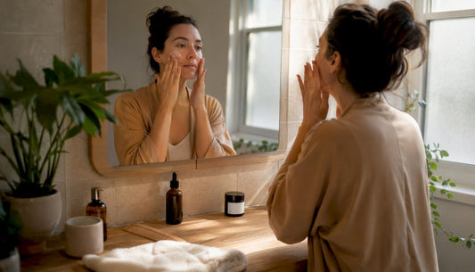 Mother applying gentle postpartum skincare at vanity