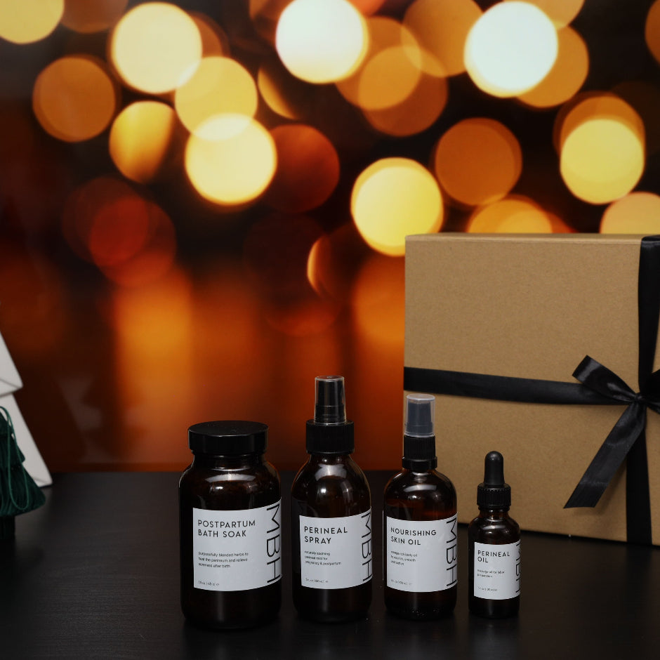 Set of skincare products with a gift box and Christmas decorations on a dark surface with blurred lights in the background.